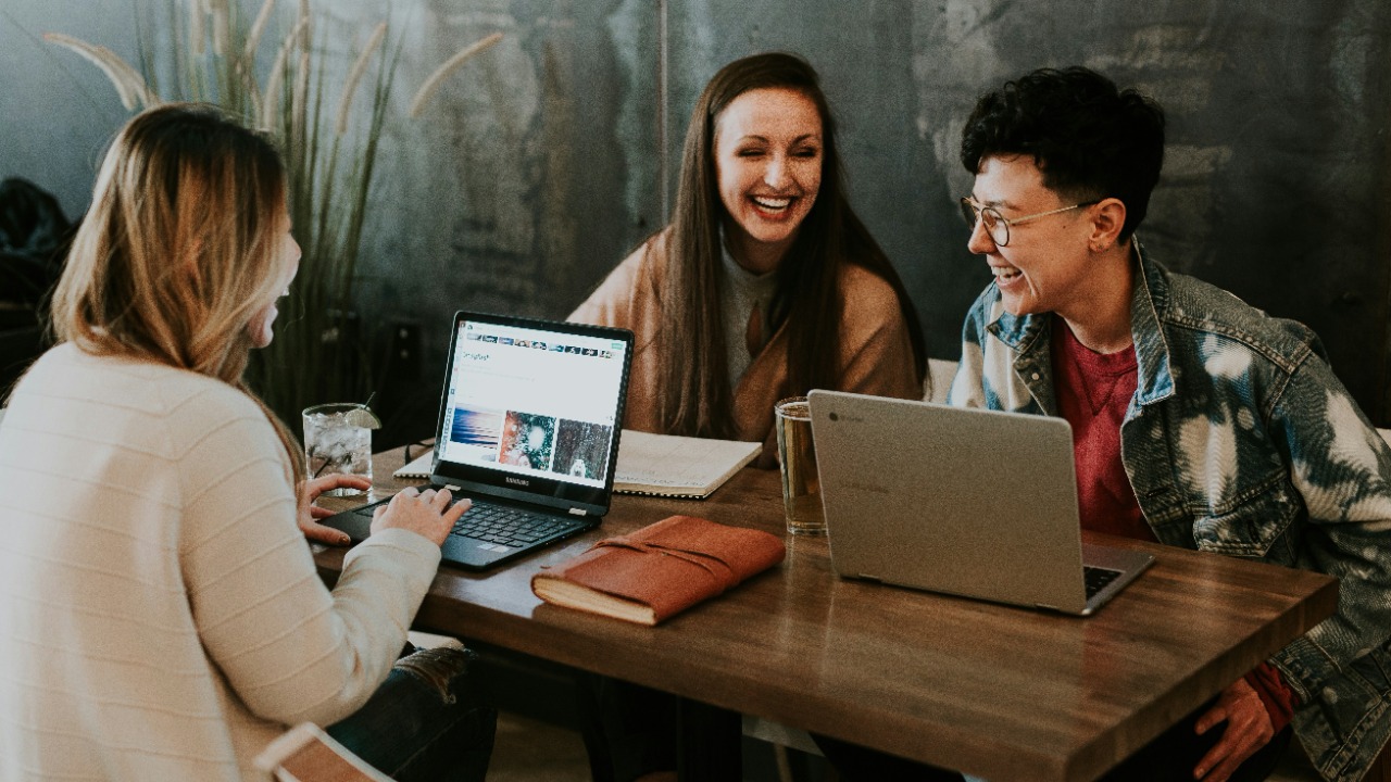 Image Credit: three people sitting in front of table laughing together — Brooke Cagle