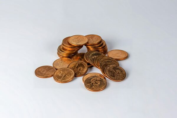 a pile of coins sitting on top of a white table — Barry A