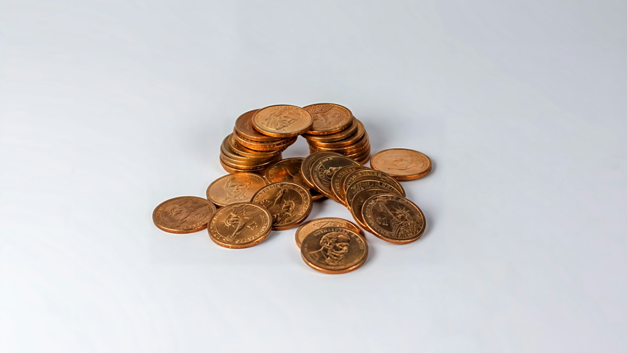 a pile of coins sitting on top of a white table — Barry A