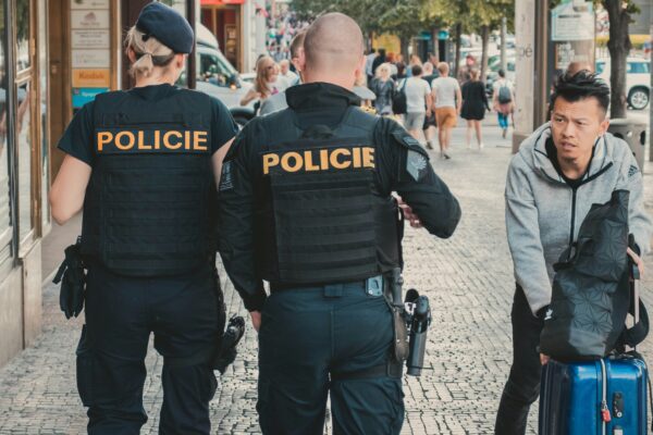 people walking at the side of the road beside buildings