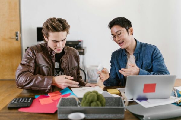 Two business professionals discuss ideas and strategies in an office setting, fostering innovation and teamwork.