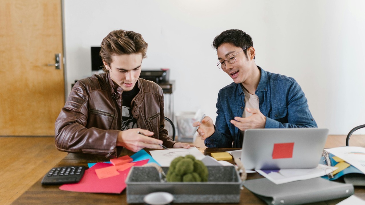 Two business professionals discuss ideas and strategies in an office setting, fostering innovation and teamwork.