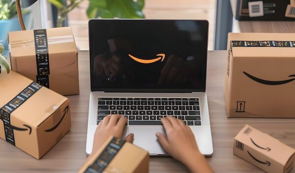 a person is typing on a laptop with boxes on the table and a box of boxes on the table
