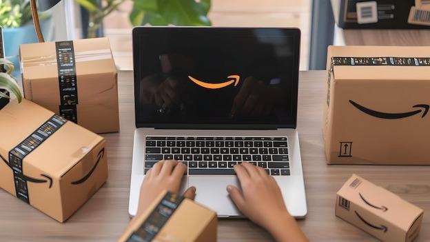 a person is typing on a laptop with boxes on the table and a box of boxes on the table