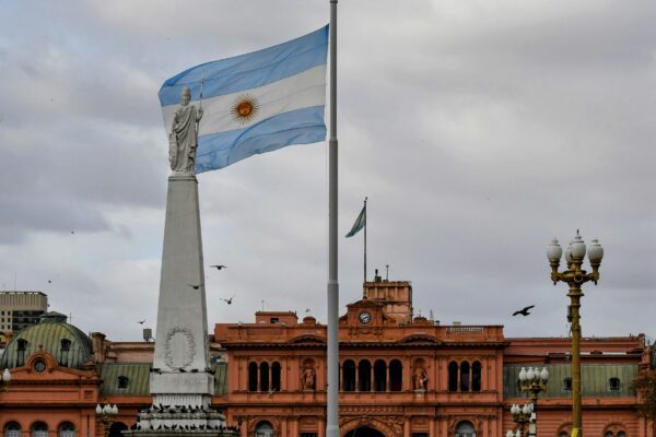 Argentinian flag waving near a prominent building.