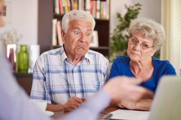 Mature male psychotherapist in protective mask listening to his patients