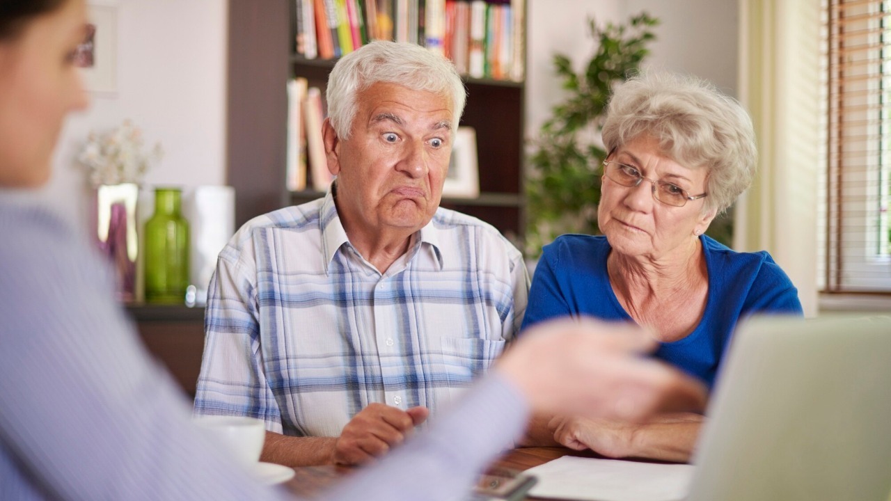 Mature male psychotherapist in protective mask listening to his patients