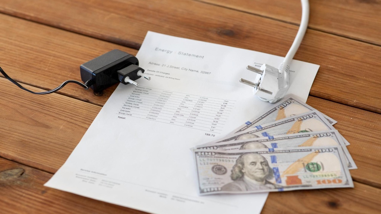 utility bill money and electric plugs on table