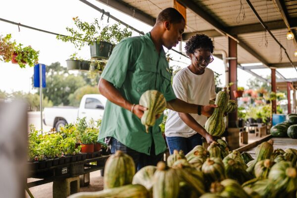 Couple shopping for gourds at an outdoor market.