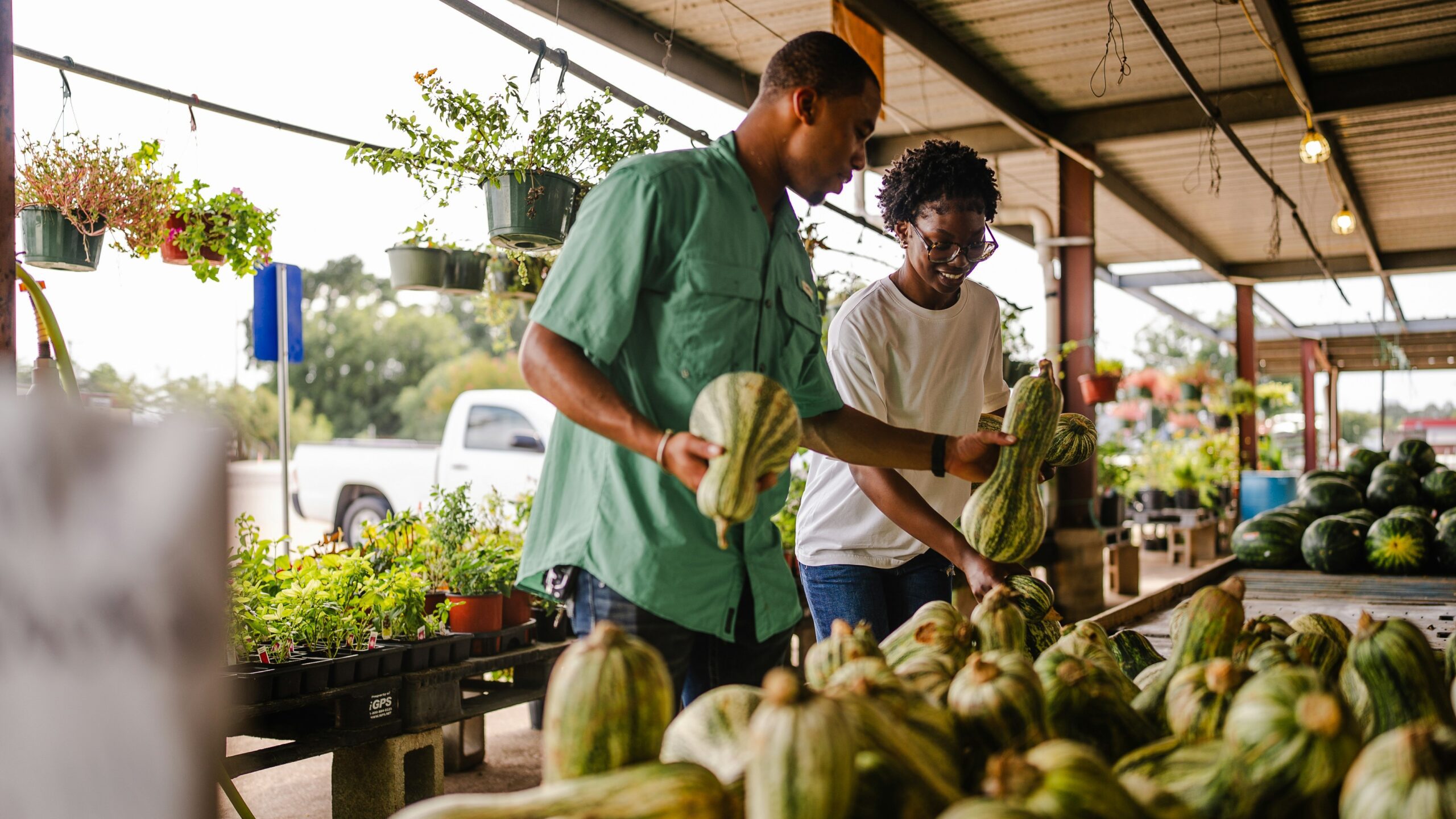Couple shopping for gourds at an outdoor market.