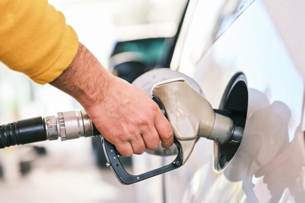 a man pumping gas into his car at a gas station