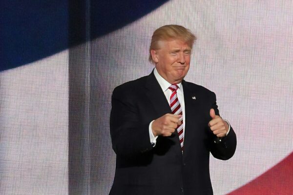 Donald Trump beside man in black suit