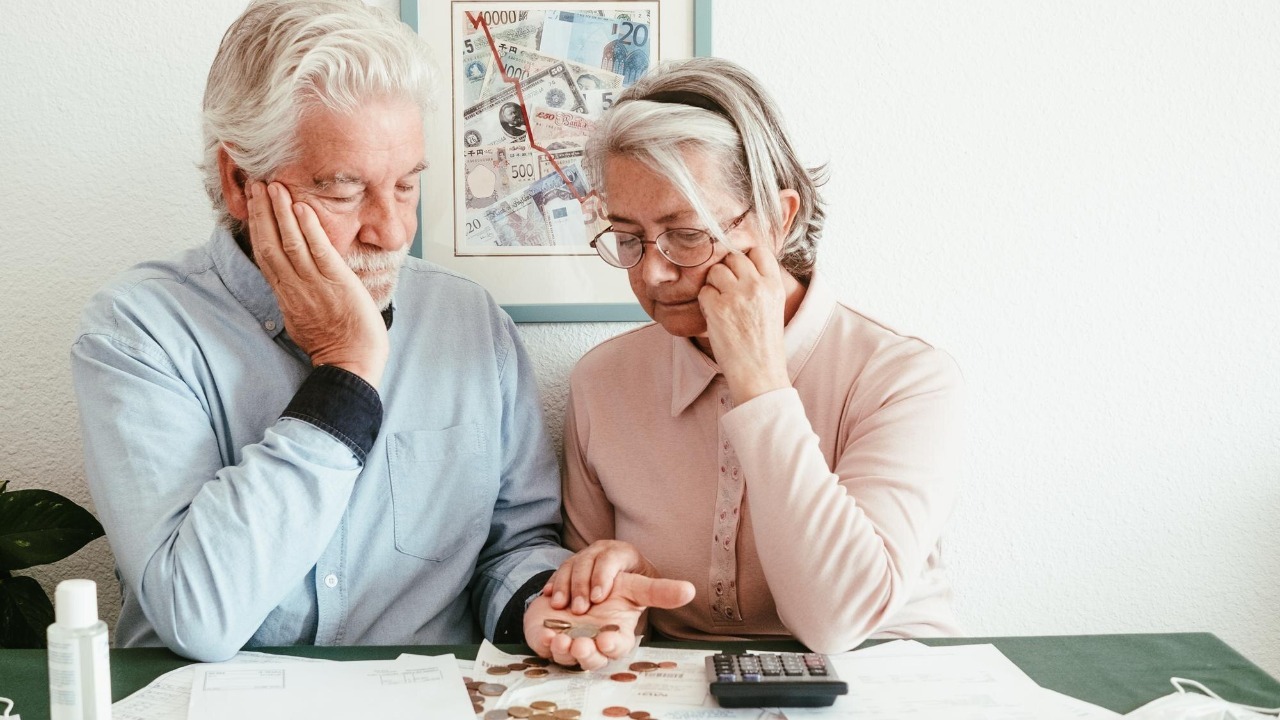 Depressed retired ssenior couple sitting at the table at home looking at their bills to be paid Economic crisis rising prices rising electricity inflation speculation concept