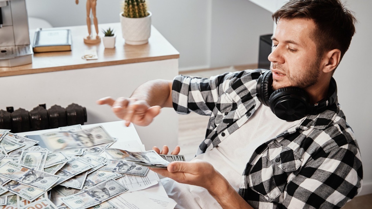 Man counts dollar banknotes at home office