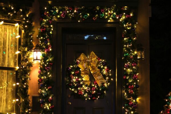 Front door decorated with christmas wreath and lights