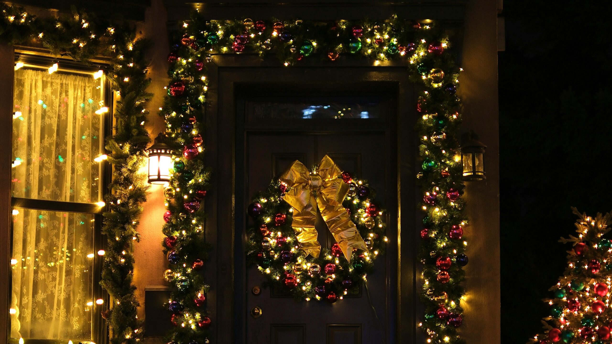Front door decorated with christmas wreath and lights