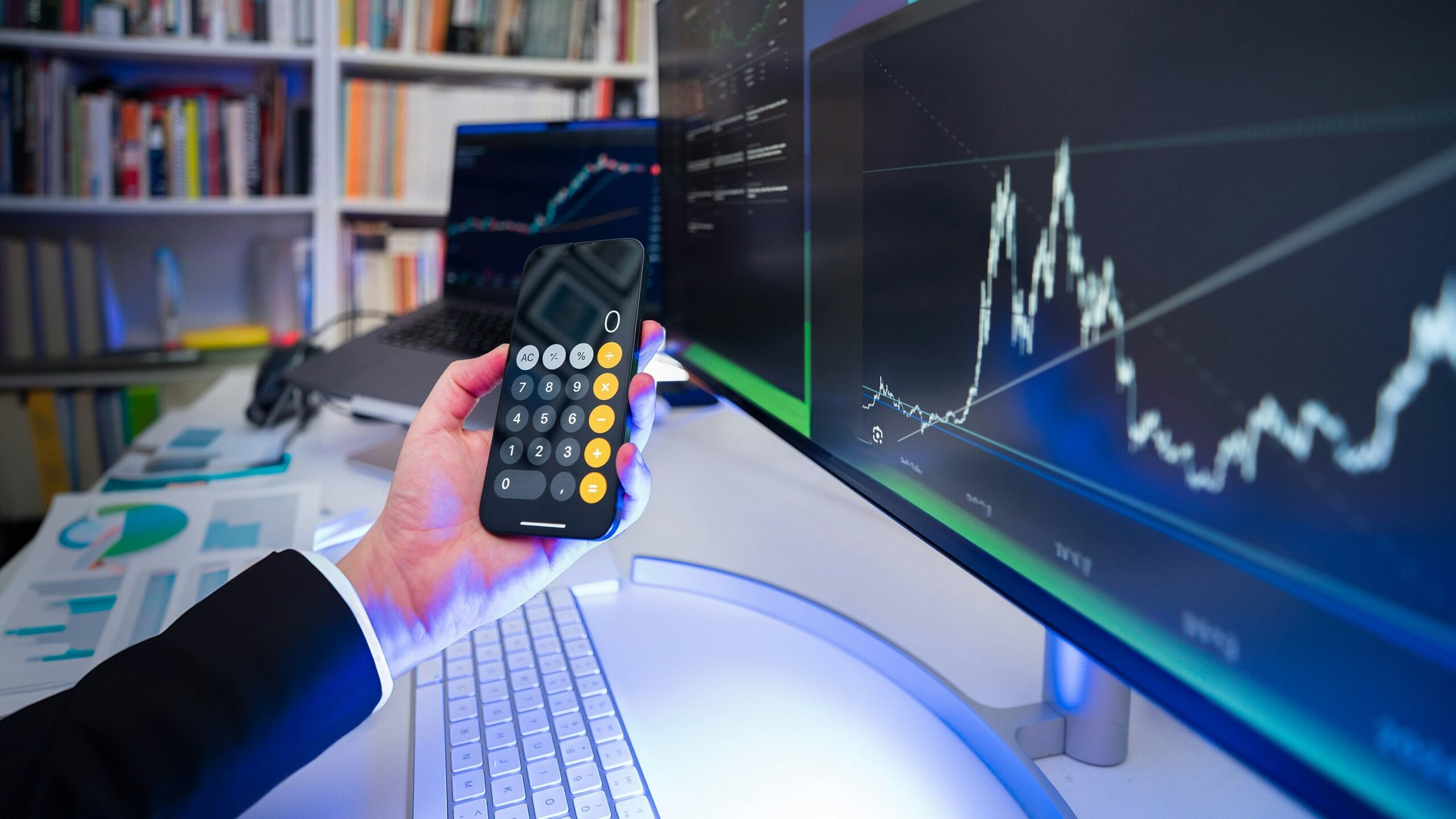A man holding a remote control in front of a computer