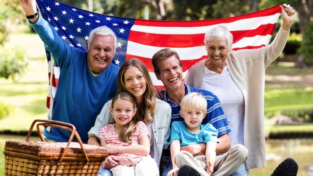 Multi-generation family holding american flag in the park