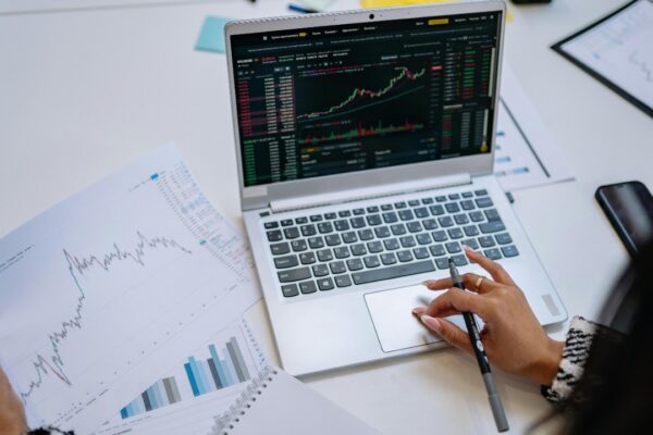 A detailed look at business analysis with a laptop displaying graphs and financial charts on a table.
