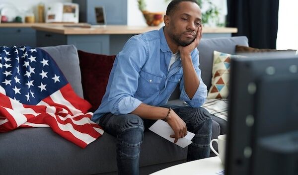 Bored man watching TV with information about election