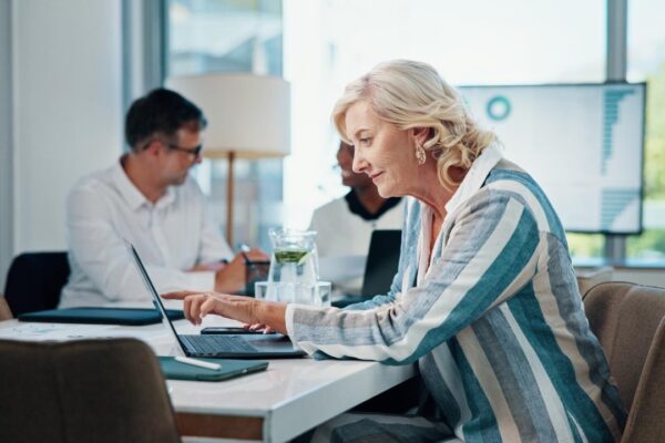 Business mature woman and meeting with laptop for research review information and financial report Person accountant and online for bookkeeping investment feedback and company revenue for growth