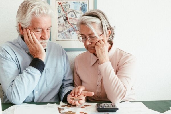 Depressed retired ssenior couple sitting at the table at home looking at their bills to be paid Economic crisis rising prices rising electricity inflation speculation concept