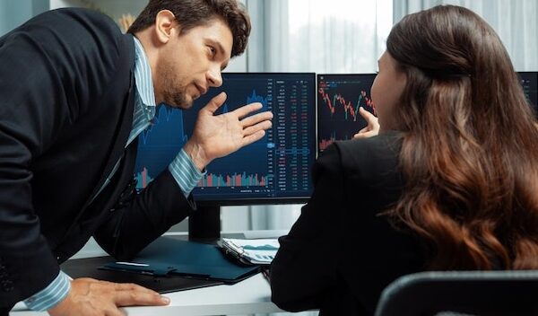Two business traders discussing business statistic on report paper postulate