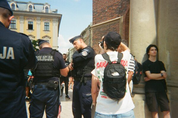 Police officers stand near civilians on a street.