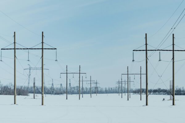 A snow covered field with power lines in the background