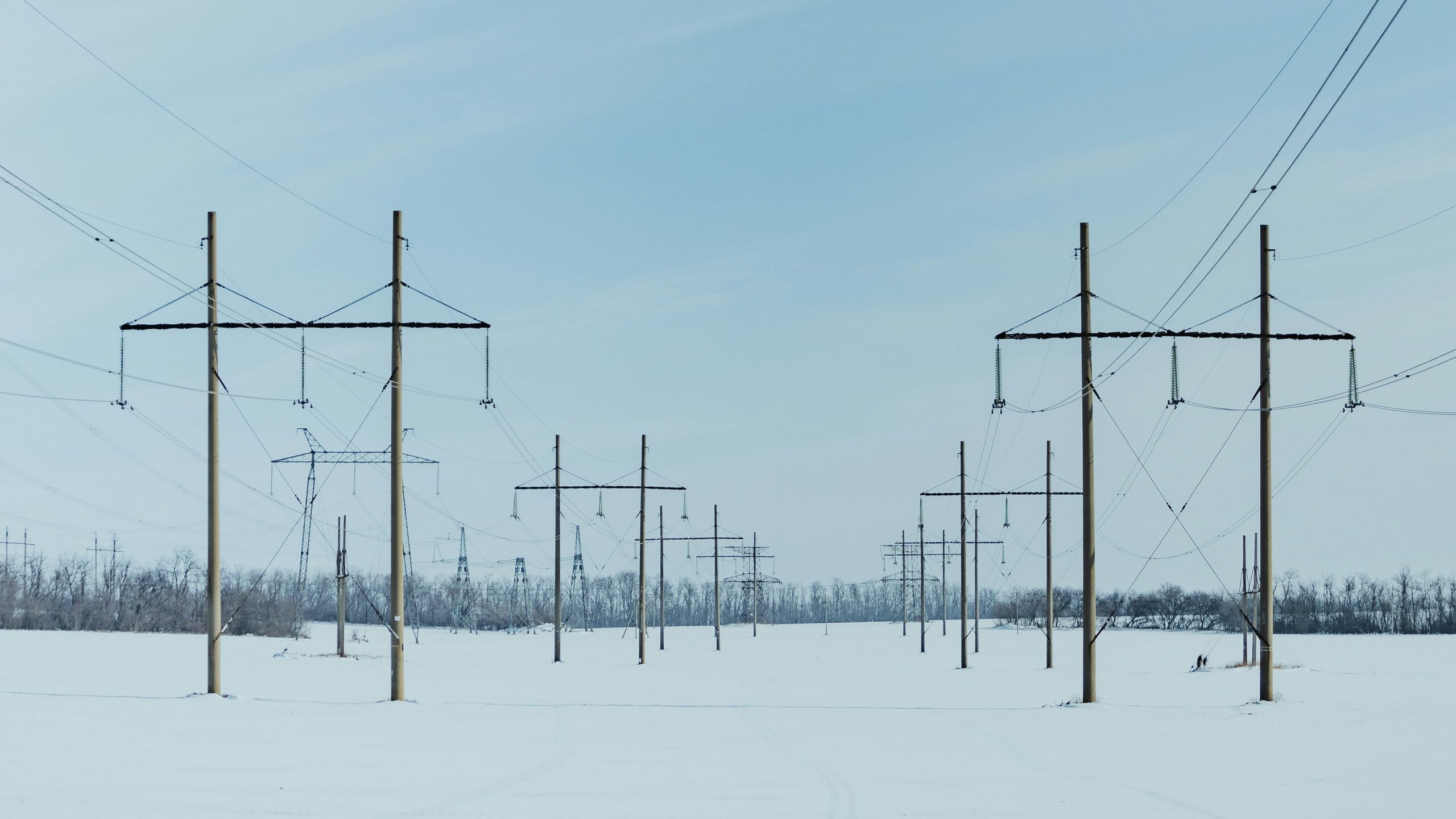 A snow covered field with power lines in the background