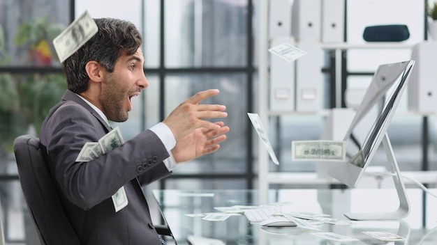 Happy emotional man in the office working with a computer