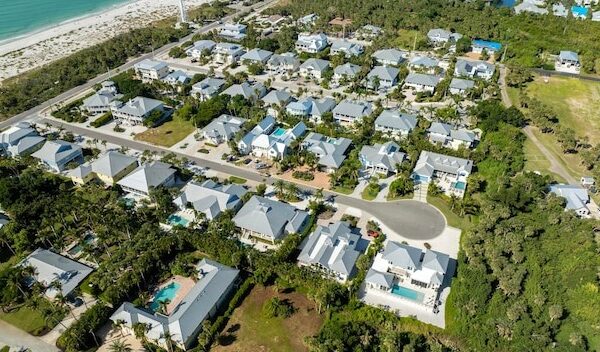 Aerial view of wealthy waterfront neighborhood Expensive mansions between green palm trees on Gulf of Mexico shore in island small town Boca Grande on Gasparilla Island in southwest Florida USA