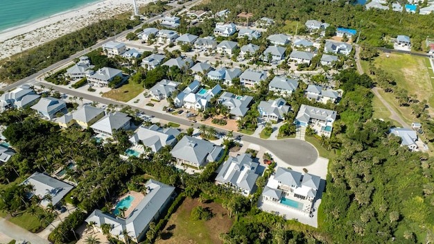 Aerial view of wealthy waterfront neighborhood Expensive mansions between green palm trees on Gulf of Mexico shore in island small town Boca Grande on Gasparilla Island in southwest Florida USA