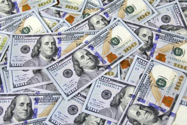 Pile of US hundred dollar bills depicting financial success and wealth.