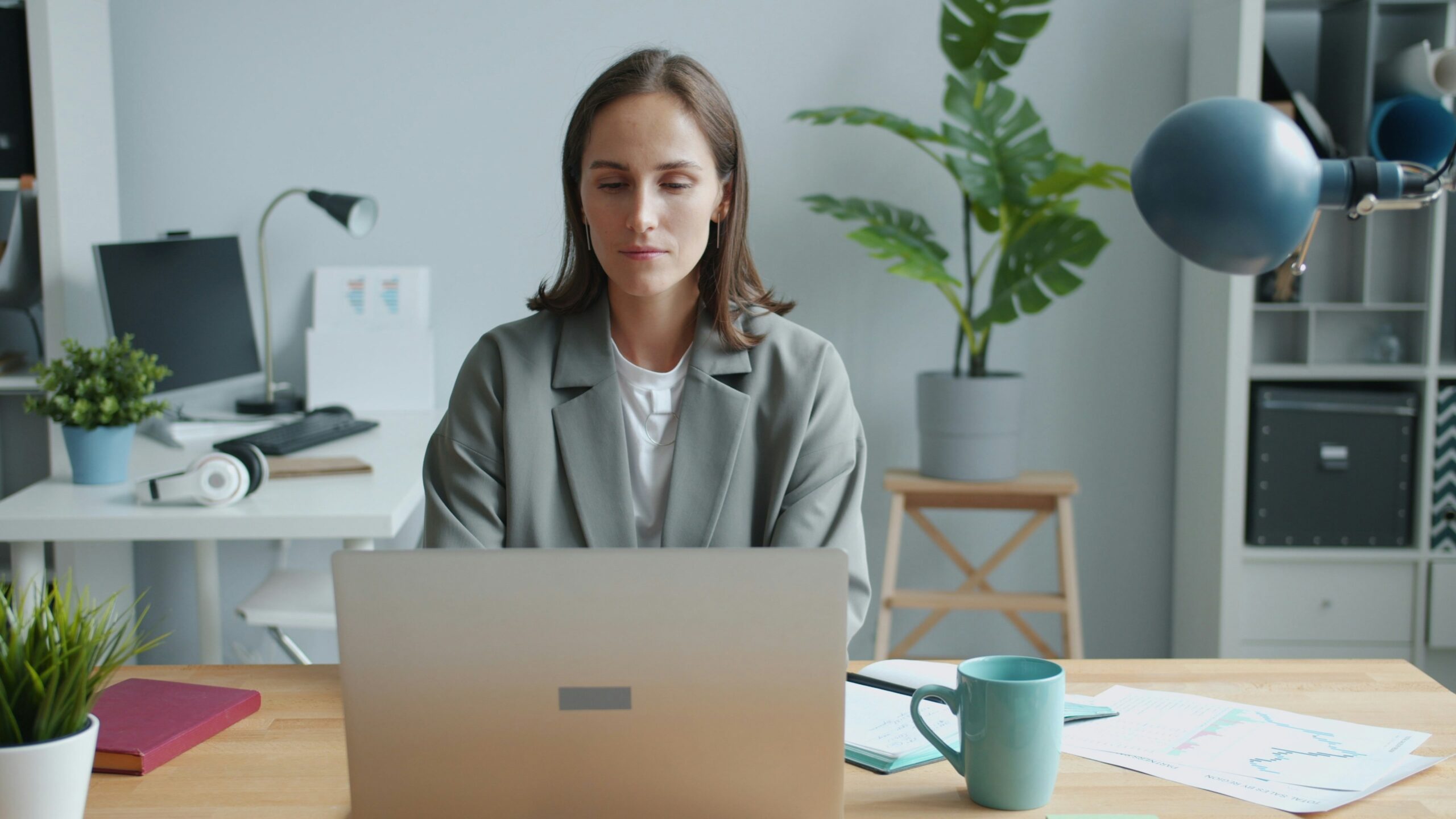 Woman working on a laptop at a desk.