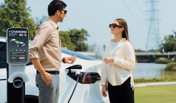 Young couple recharge EV car battery at charging station Expedient