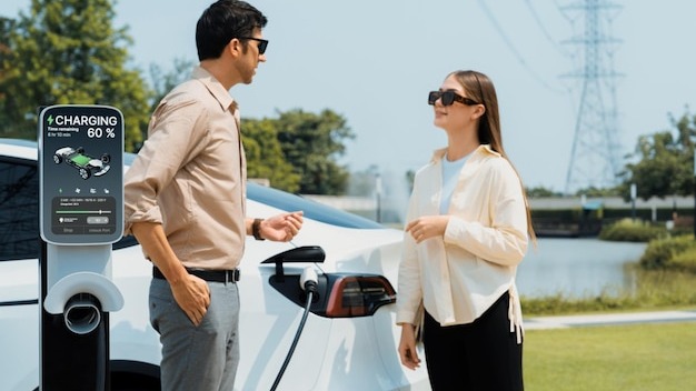 Young couple recharge EV car battery at charging station Expedient