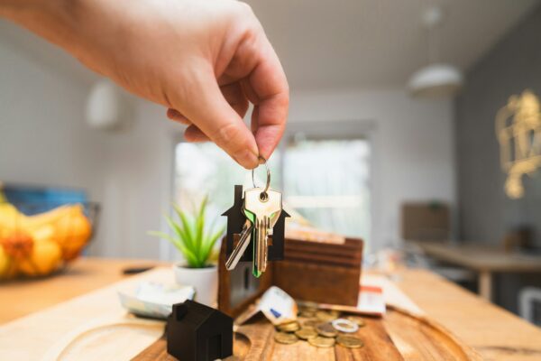 A person holding a piece of wood on top of a wooden table