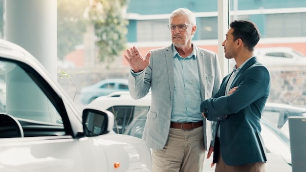Car dealership report or salesman with customer talking for vehicle history details or features Transport people or seller with client in showroom for negotiation travel or decision for purchase