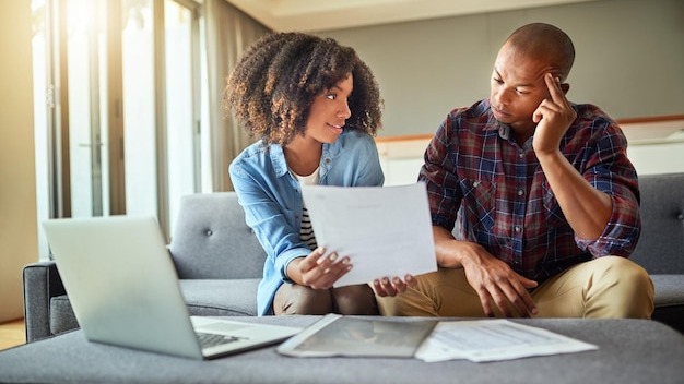 What do you think of this idea Shot of a focused young couple working on a laptop and doing paperwork together while being seated on a couch at home