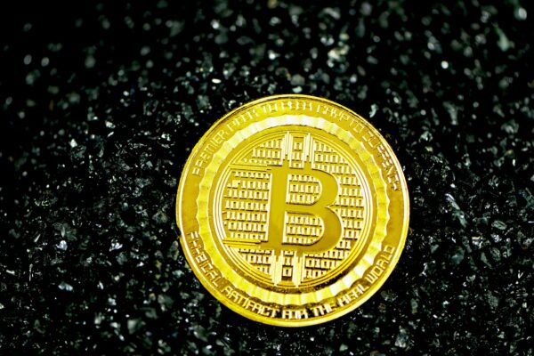 gold round coin on black surface