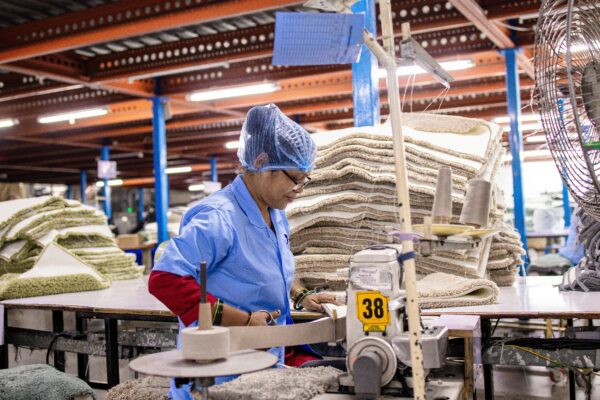 A worker operates machinery in a textile factory.