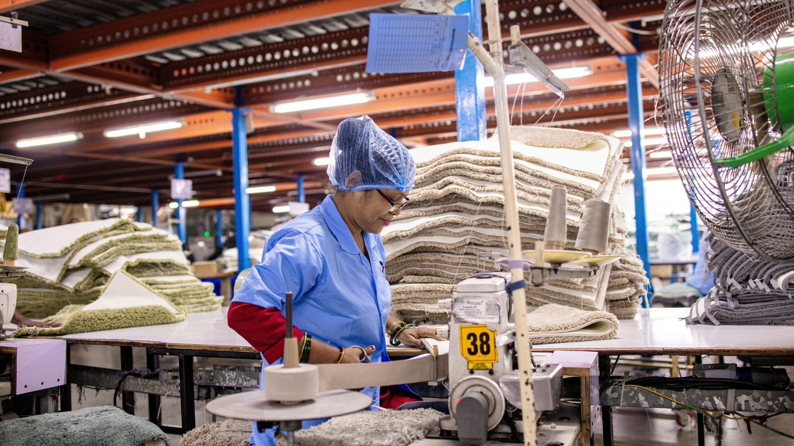 A worker operates machinery in a textile factory.