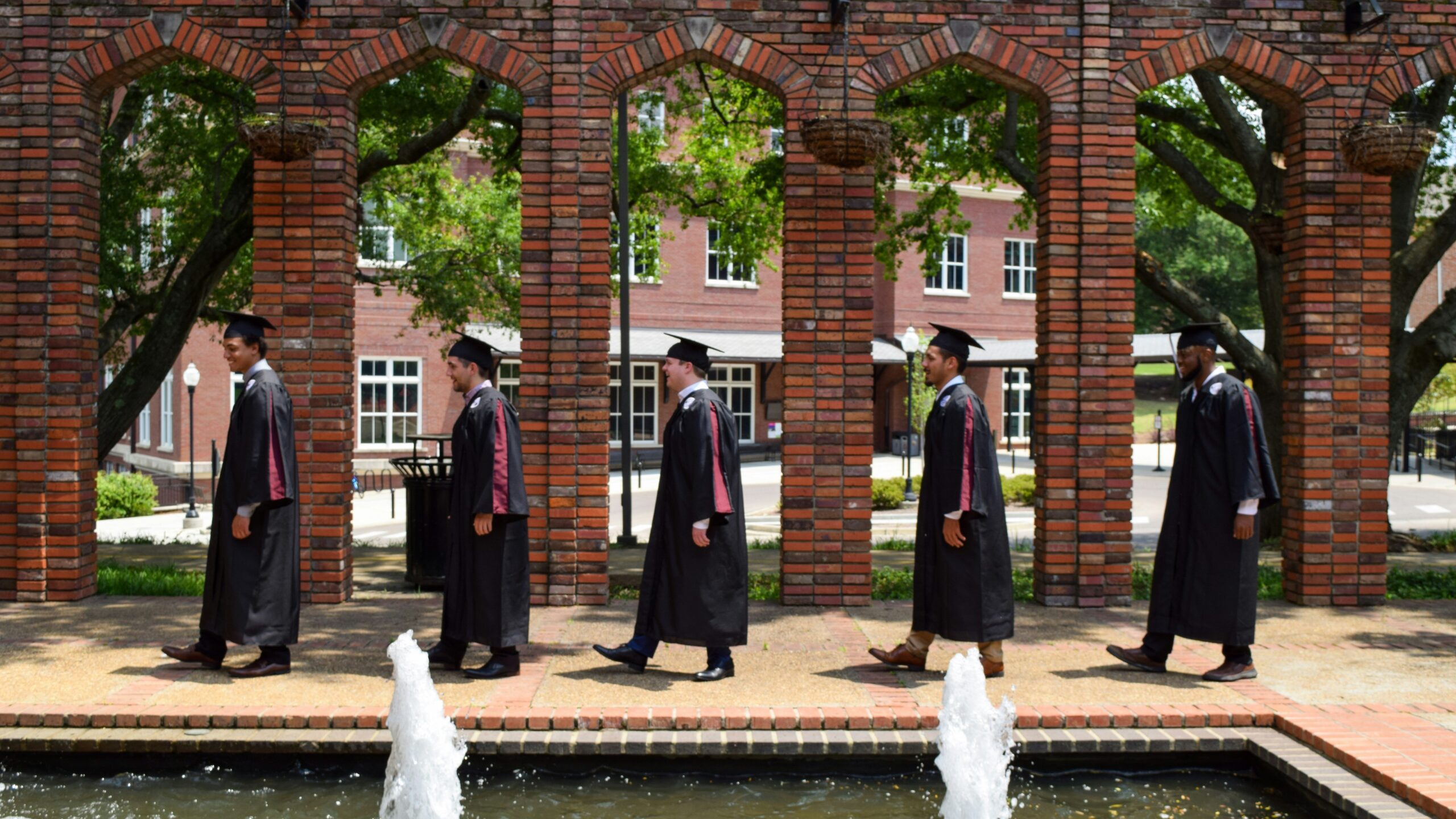 a group of men in uniform standing next to a fountain