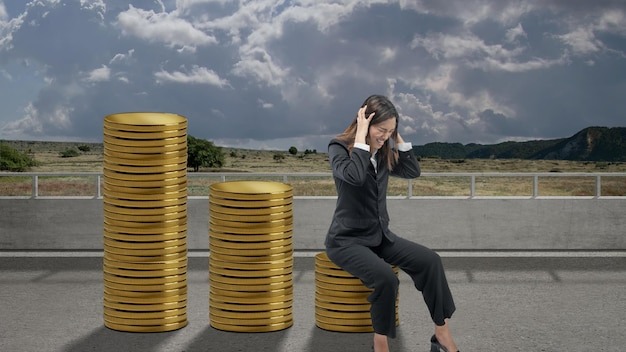 Asian businesswoman sitting on decreasing coin graph