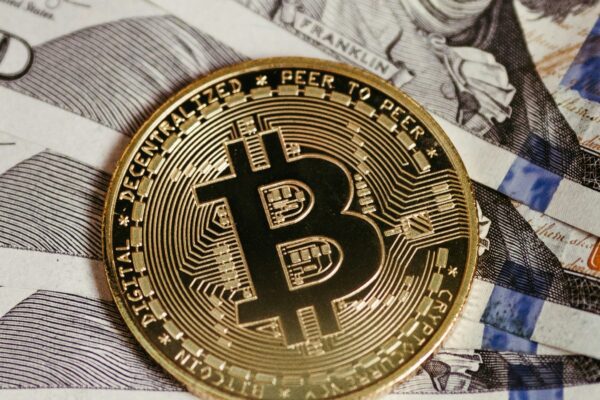 a bitcoin sitting on top of a pile of money