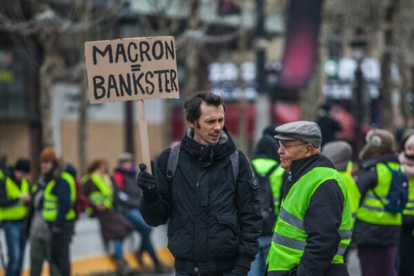 man holding gray signage