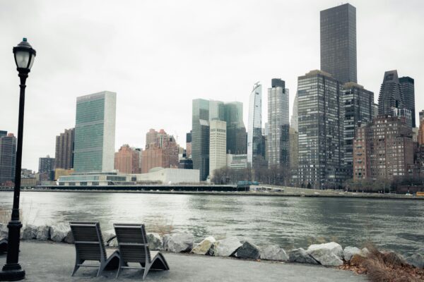 a couple of chairs sitting on the side of a river