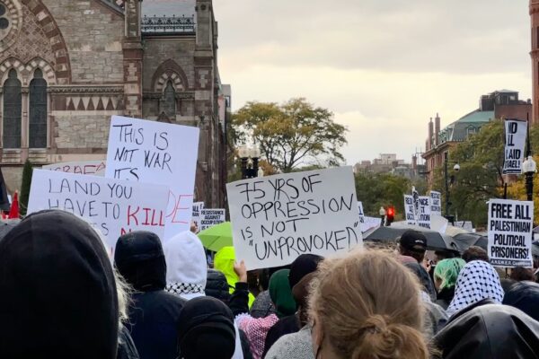 a crowd of people holding signs in front of a church