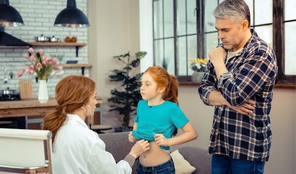 Worried father. Serious thoughtful man standing behind his daughter while thinking about her health